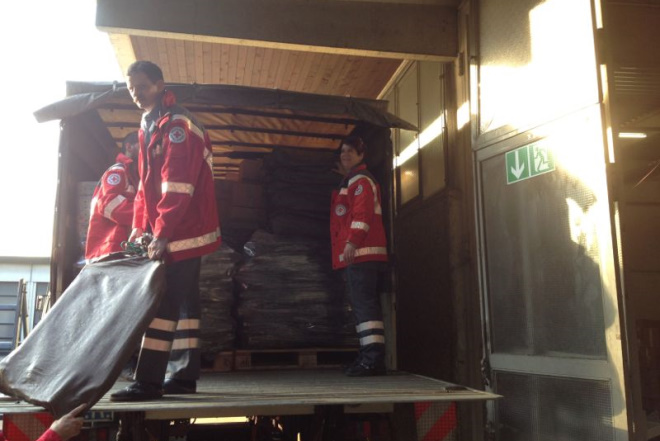Drei Helfer beladen den LKW mit den zu transportierenden Hilfsgütern.